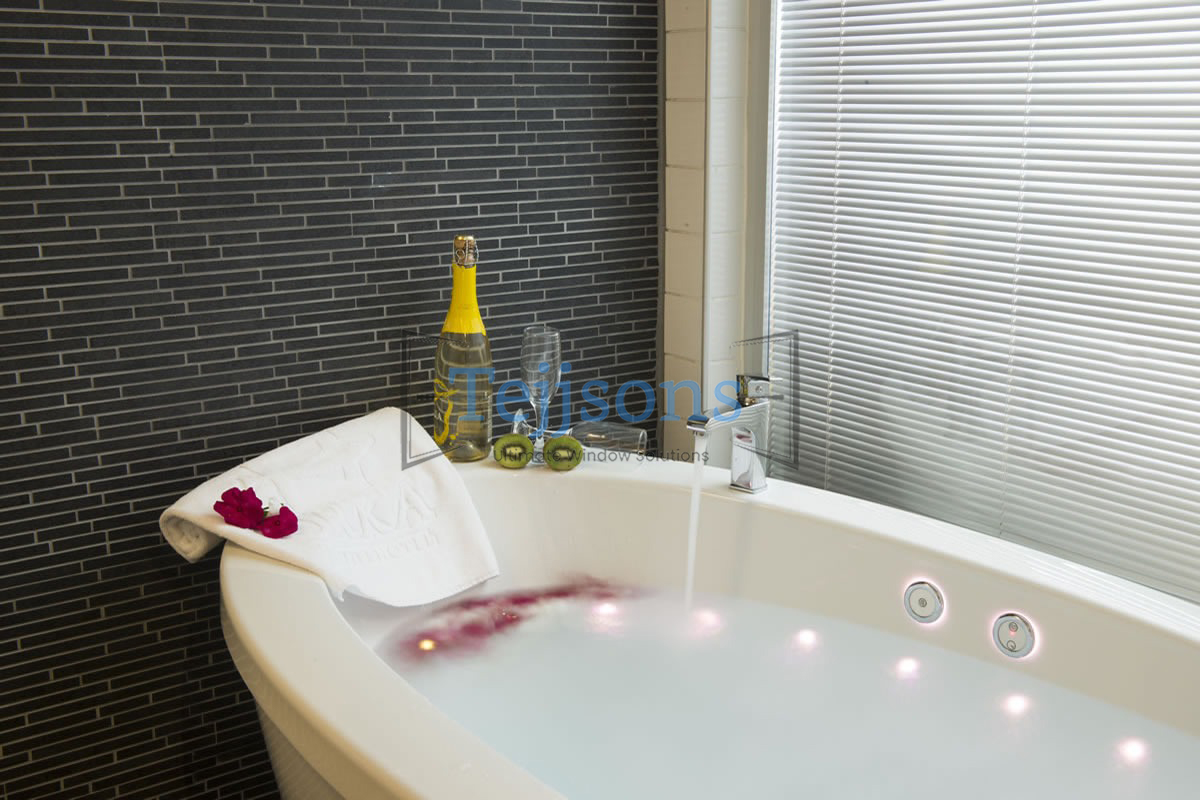 Integral blinds inside bathroom glass window by a luxury bathtub