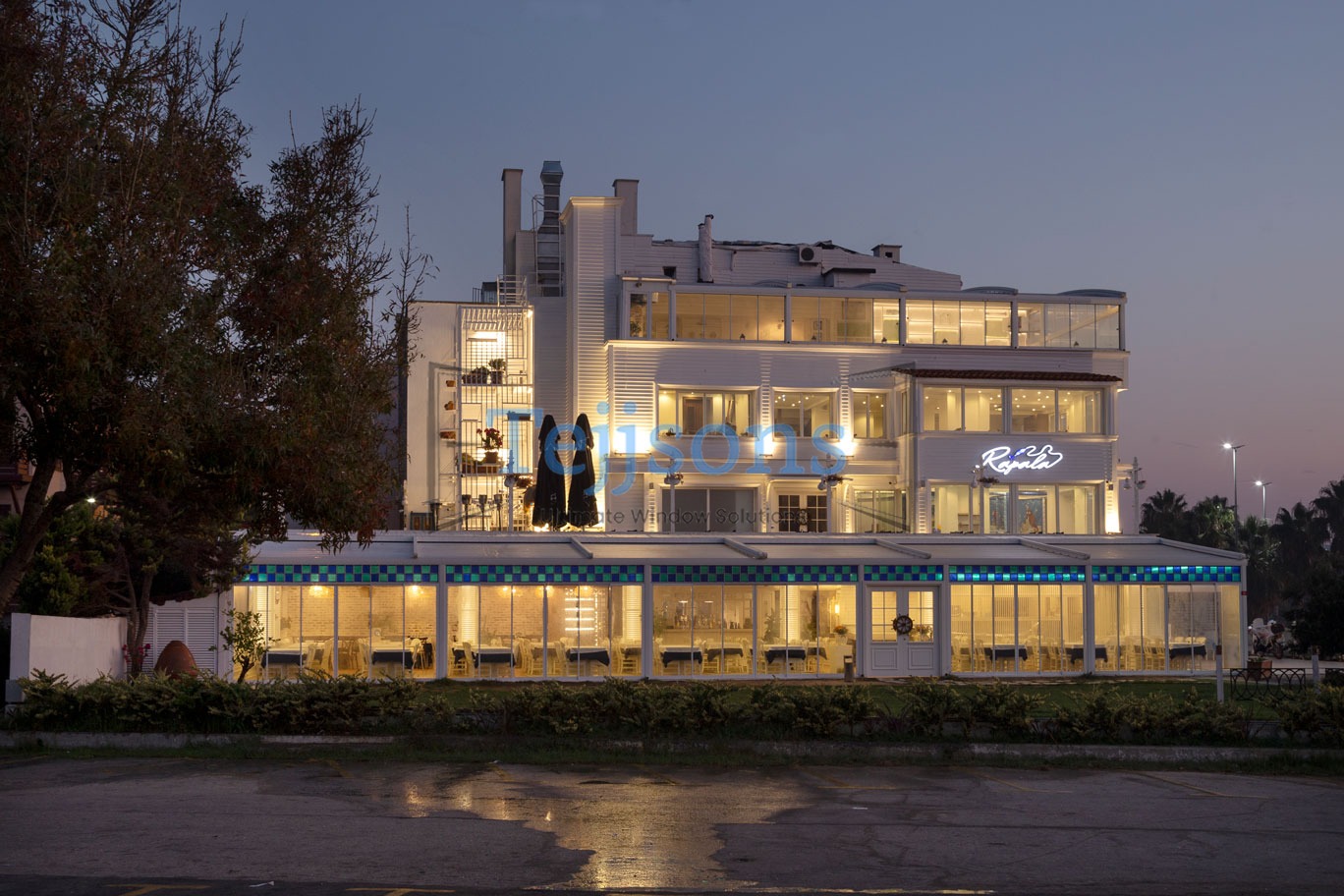 Modern white building with a lit pergola at dusk