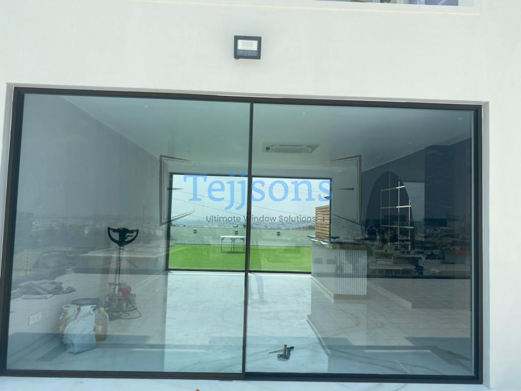 Oversized motorised sliding glass windows facing private pool garden