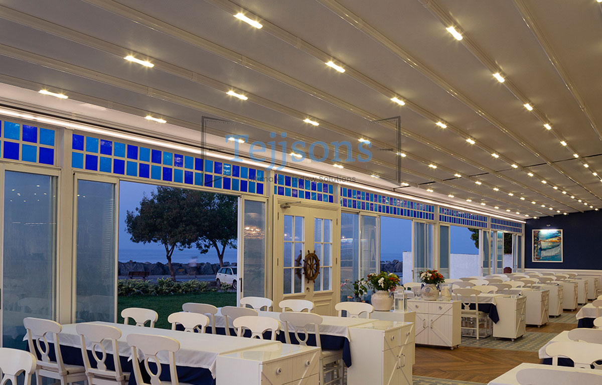 Retractable pergola with integrated LED lights over dining area