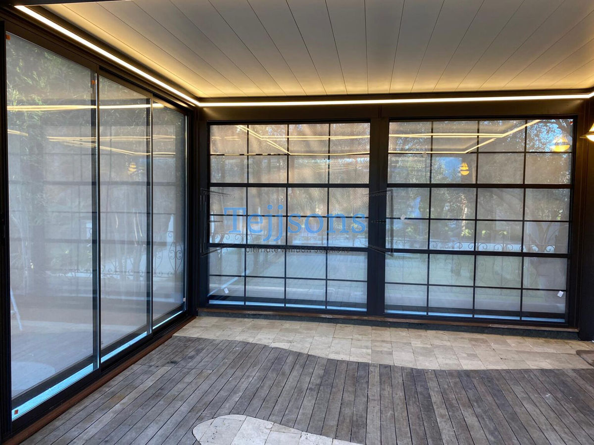Indoor sunroom patio enclosed by aluminium casement windows featuring internal Georgian bars